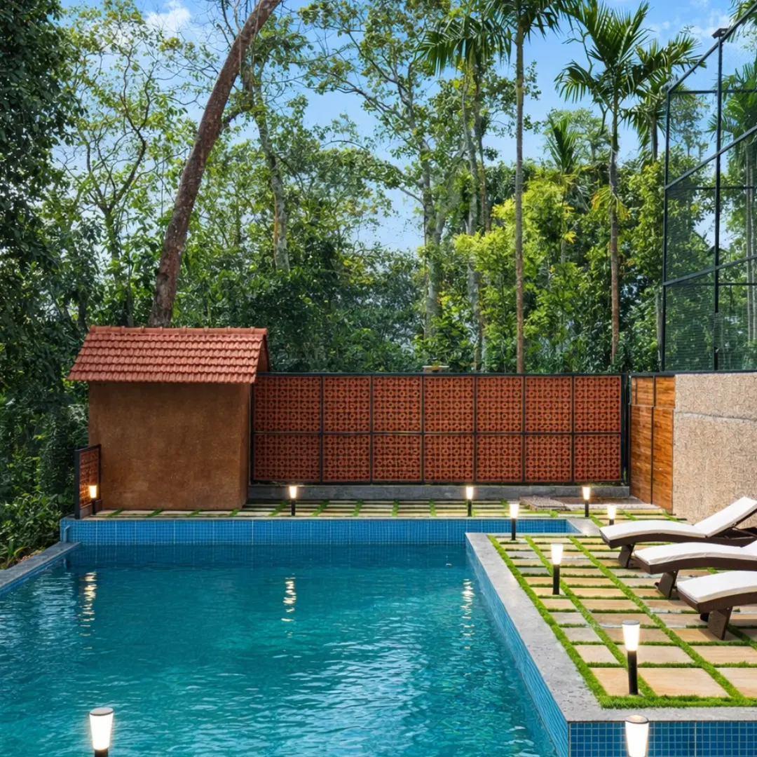 Private swimming pool surrounded by greenery at the luxury villa in Coorg
